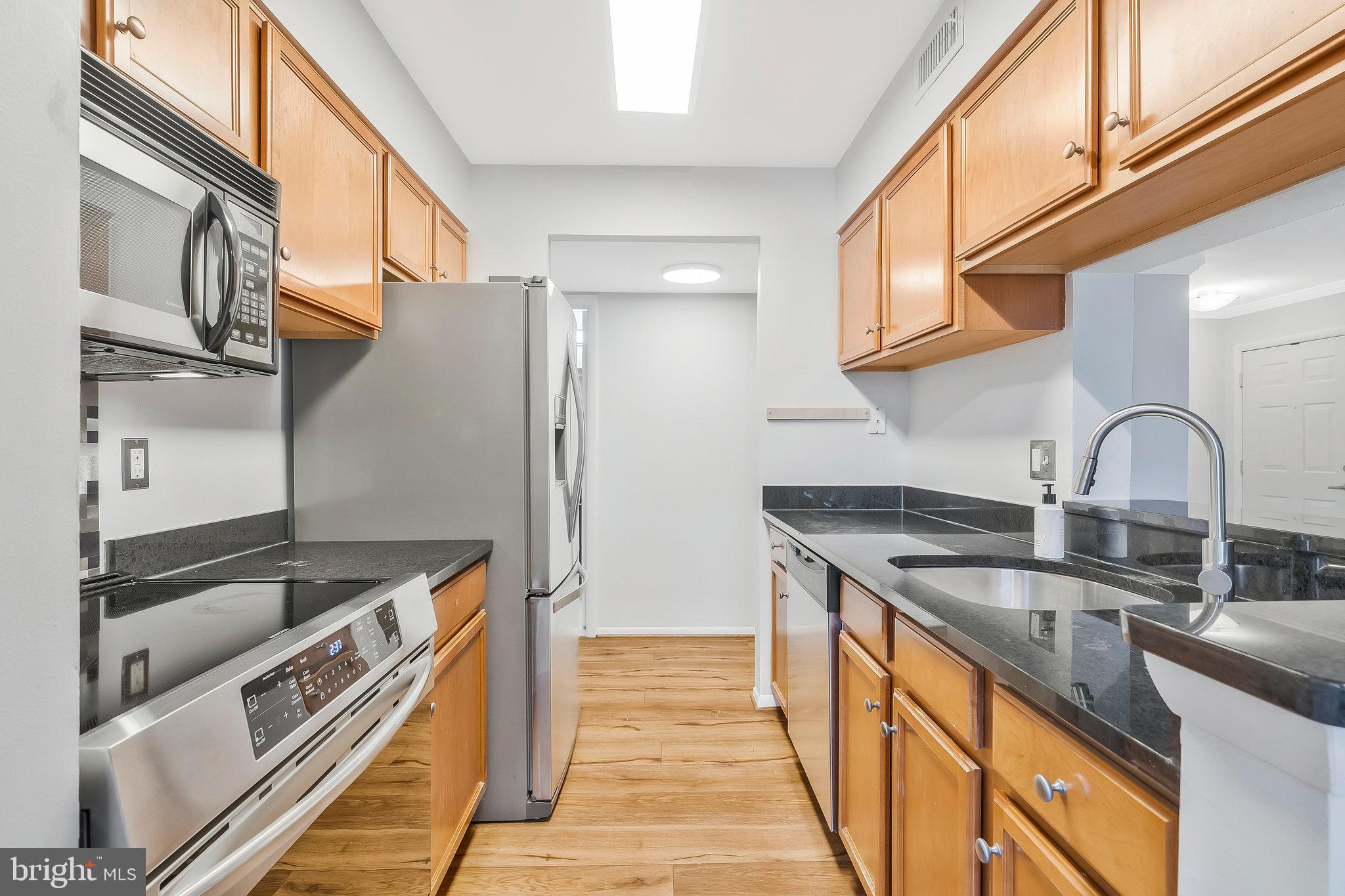 1701 Ascot Way, Unit 1701A Reston, VA 20190 - Photo 16 of 32 a kitchen with granite countertop a sink and a refrigerator