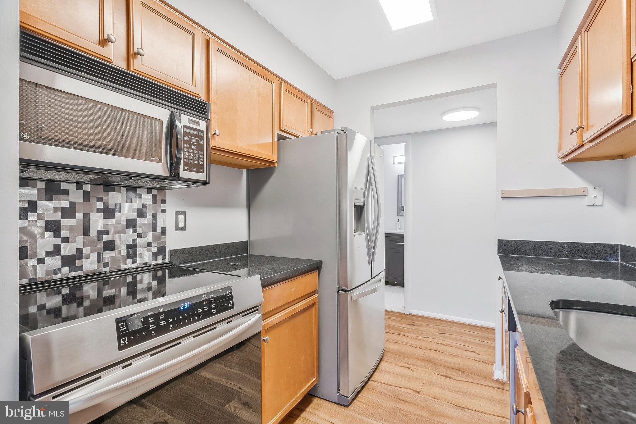 1701 Ascot Way, Unit 1701A Reston, VA 20190 - Photo 17 of 32 a kitchen with stainless steel appliances granite countertop a stove and a refrigerator