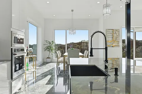 a living room with furniture a flat screen tv and a floor to ceiling window