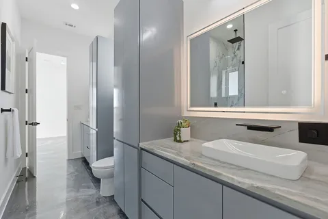 a bathroom with a granite countertop sink and a mirror