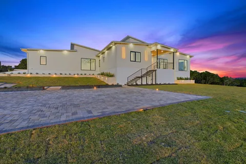 a view of an house with backyard and a yard