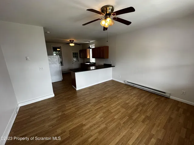 an empty room with wooden floor a ceiling fan and closet