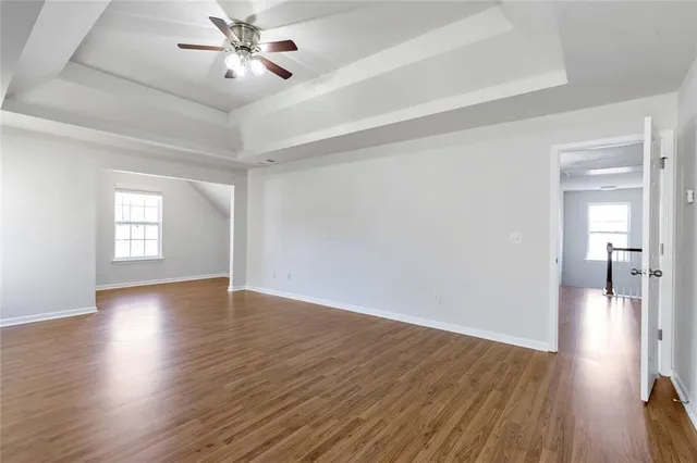 a view of a room with wooden floor and ceiling fan