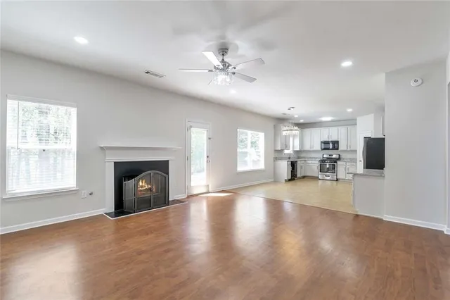 a view of empty room with wooden floor and fireplace