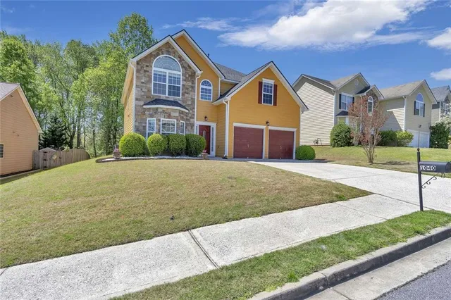 a front view of a house with a yard and garage
