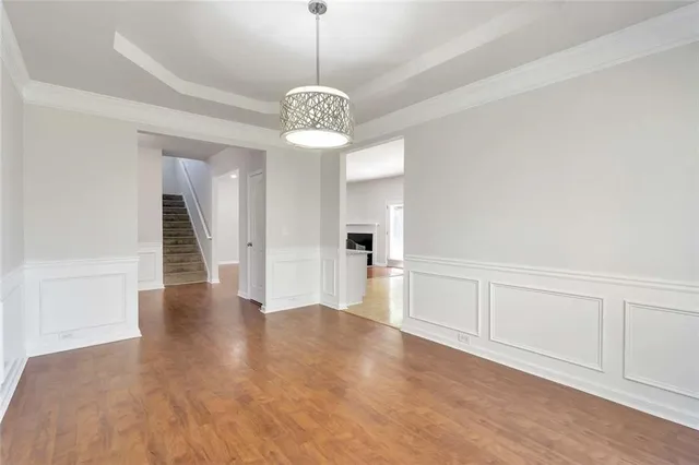 a view of a hallway with wooden floor and a chandelier
