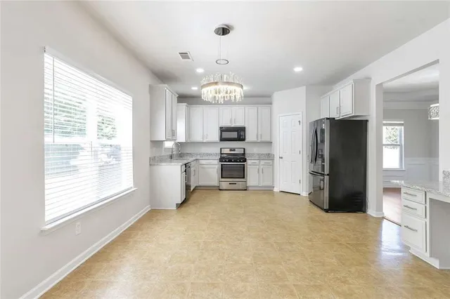a kitchen with stainless steel appliances a refrigerator and a stove top oven