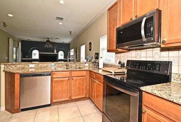 a kitchen with stainless steel appliances granite countertop a stove microwave and refrigerator