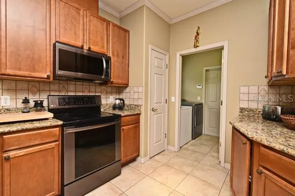 a kitchen with stainless steel appliances granite countertop a stove microwave and sink