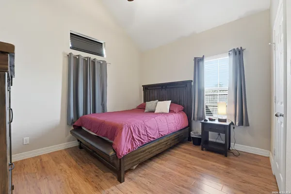 a bed sitting in a bedroom next to a window and a wooden floor