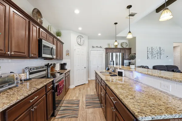 a kitchen with stainless steel appliances granite countertop a sink stove and refrigerator