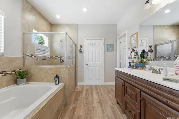 a bathroom with a bathtub a sink a mirror and a shower