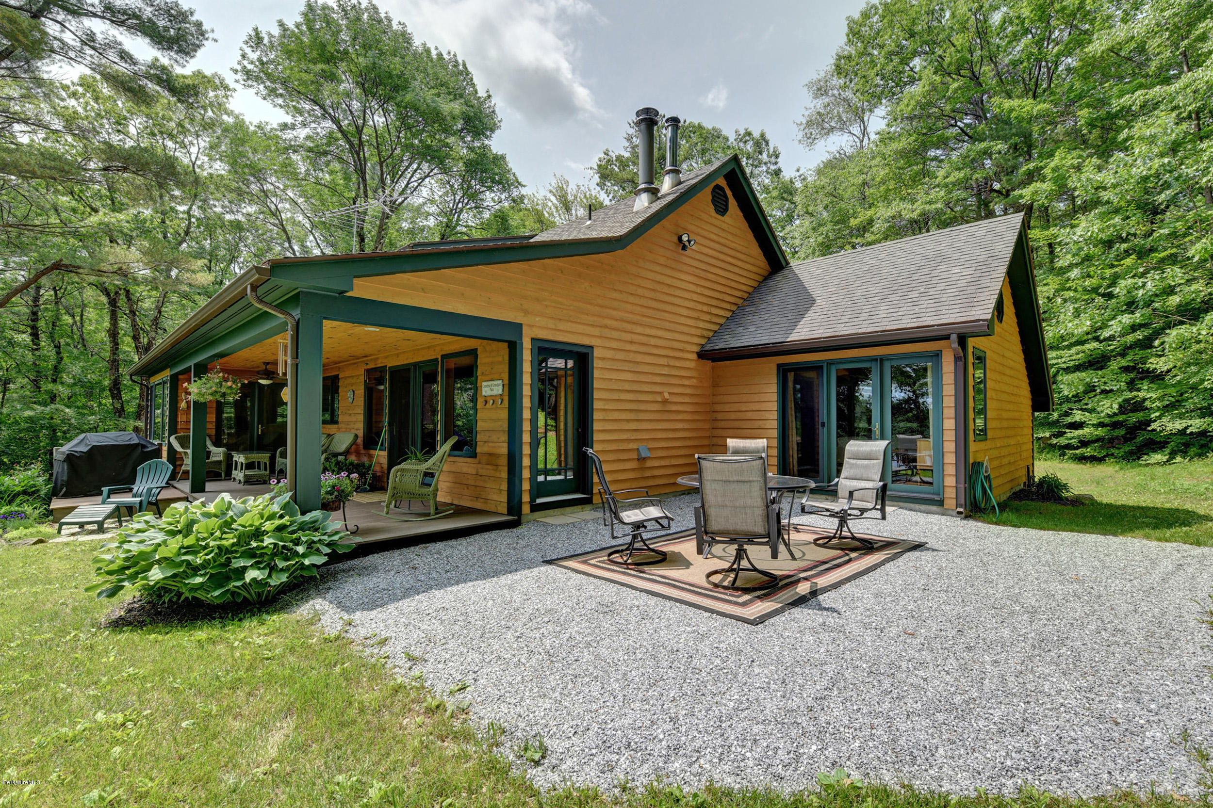 17A Goose Pond Road Tyringham, MA 01238 - Photo 18 of 29 a view of a patio with a table and chairs under an umbrella