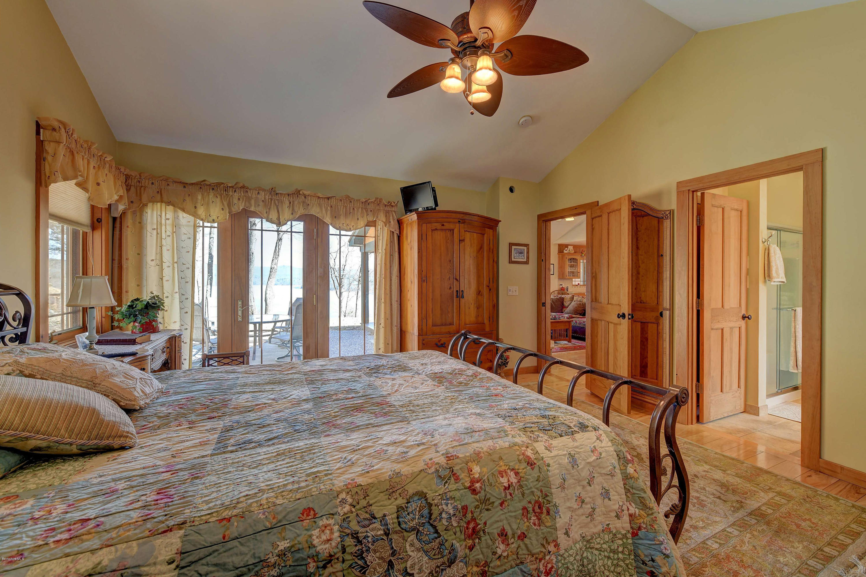 17A Goose Pond Road Tyringham, MA 01238 - Photo 8 of 29 a spacious bedroom with a large bed and a chandelier