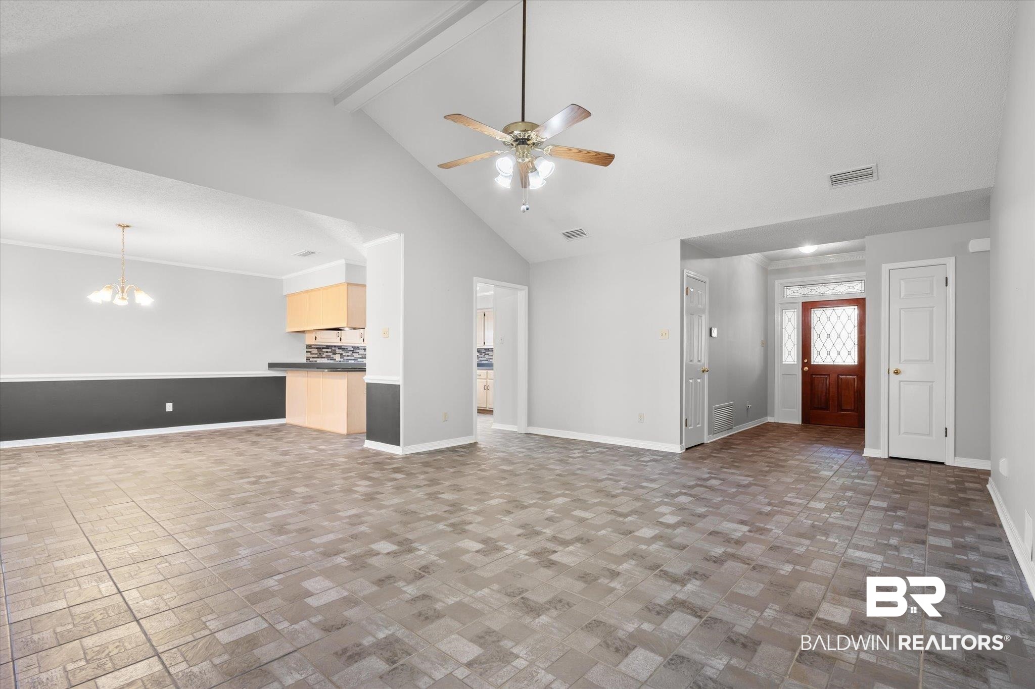 7410 East Lakeview Drive Mobile, AL 36695 - Photo 2 of 20 Unfurnished living room featuring ceiling fan with notable chandelier, beam ceiling, and high vaulted ceiling