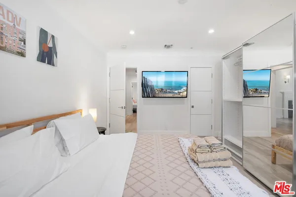 a bedroom with a bed and a flat screen tv
