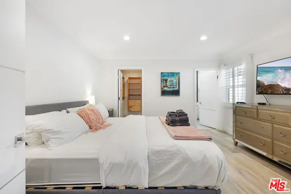 a bedroom with a bed and a flat screen tv