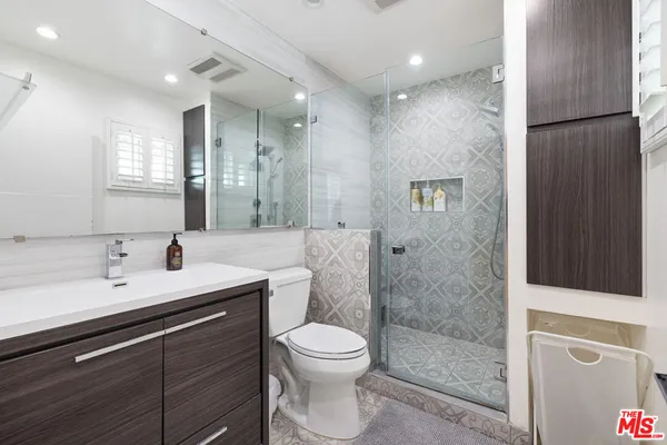 a bathroom with a double vanity sink toilet and shower