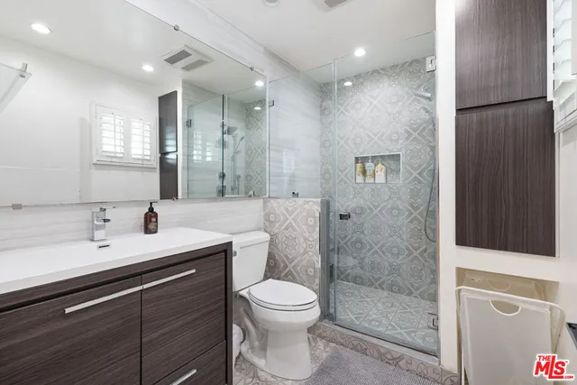 a bathroom with a double vanity sink toilet and shower