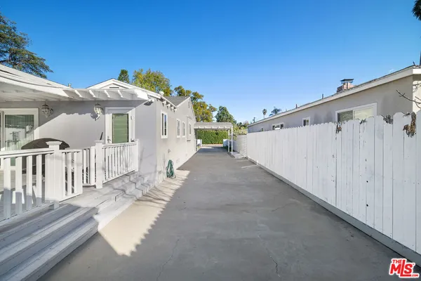 a view of a house with a wooden fence