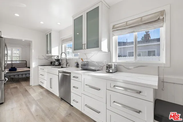 a kitchen with granite countertop white cabinets and white appliances