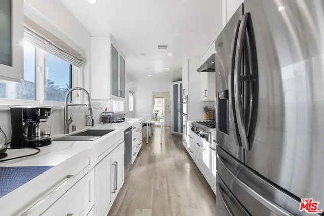 a large kitchen with a large window and stainless steel appliances