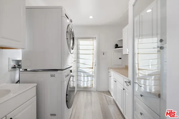 a bathroom with a granite countertop sink a washer and dryer