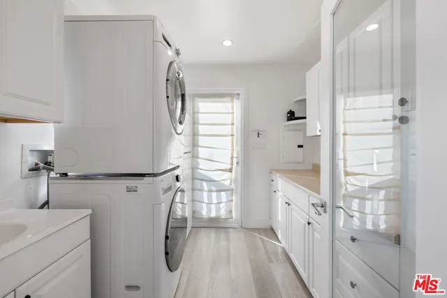 a bathroom with a granite countertop sink a washer and dryer