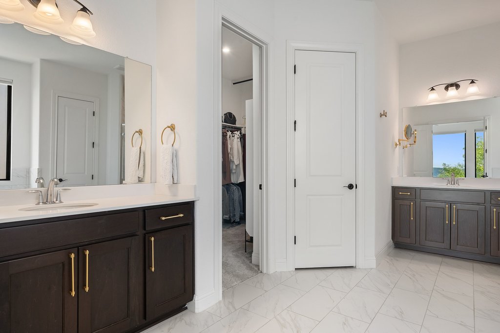 1221 Siena Sunset Road Leander, TX 78641 - Photo 22 of 39 Dual dark wood vanities with gold-finish hardware and white countertops