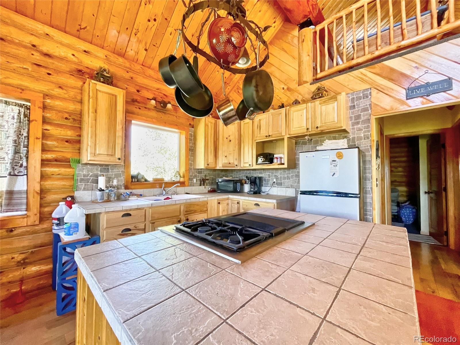 43 Pintail Road Como, CO 80432 - Photo 3 of 34 a kitchen with stainless steel appliances granite countertop a stove a sink dishwasher and cabinets with wooden floor