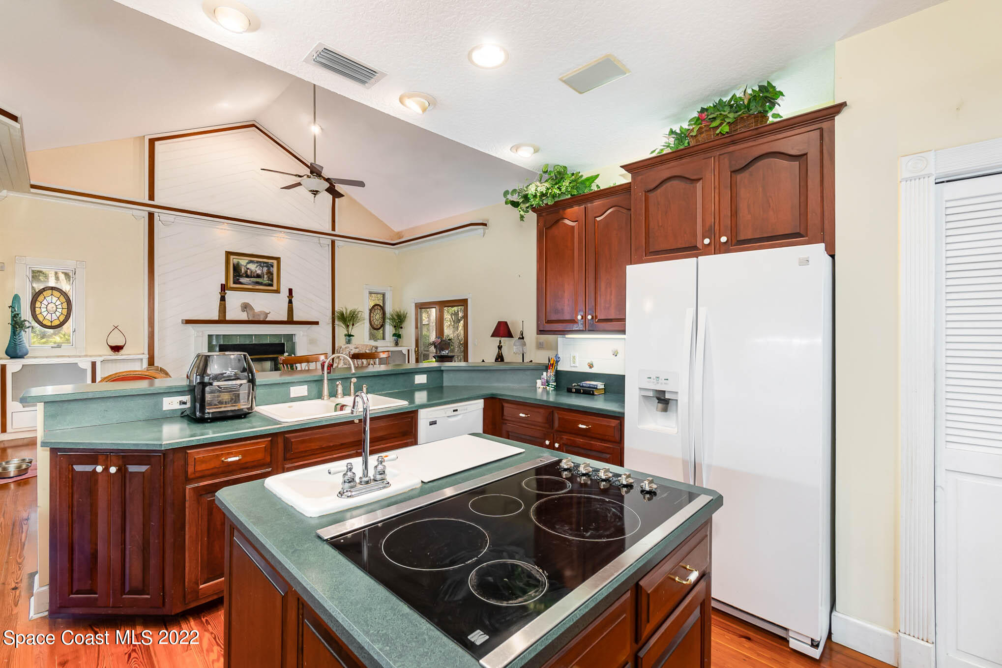 3440 Carter Road Mims, FL 32754 - Photo 9 of 36 a kitchen with stainless steel appliances granite countertop a stove a refrigerator and a sink with wooden cabinets