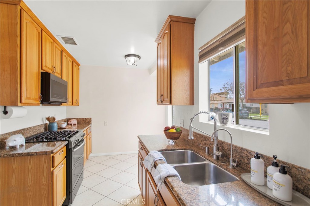 11339 Cecilia Street Downey, CA 90241 - Photo 6 of 17 a white kitchen with a sink and a large window
