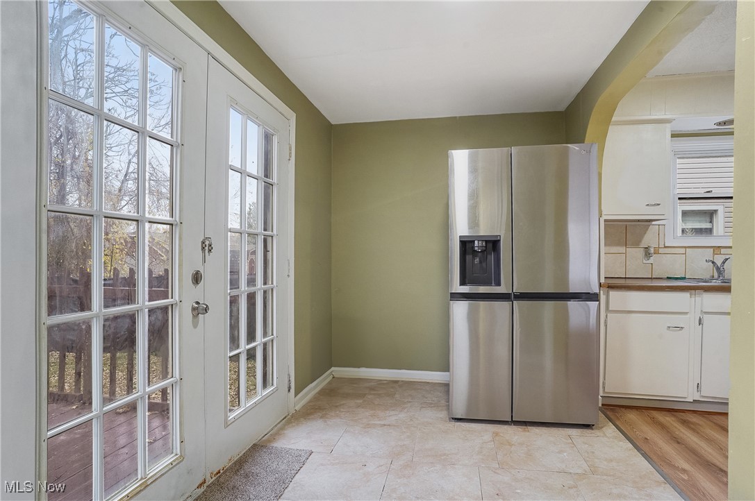 888 Dan Street Akron, OH 44310 - Photo 19 of 36 Kitchen featuring white cabinets, stainless steel refrigerator with ice dispenser, backsplash, and french doors