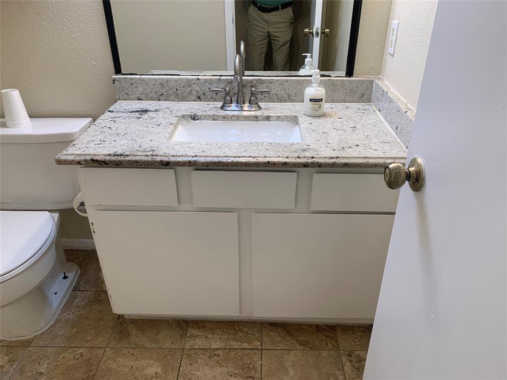 12482 Abrams Road, Unit 1303 Dallas, TX 75243 - Photo 14 of 30 White vanity with an integrated sink, speckled stone countertop, and chrome faucet