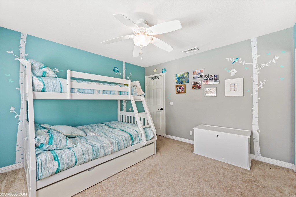 1179 Patricia Circle Vista, CA 92084 - Photo 21 of 48 a bedroom with a bed and a ceiling fan