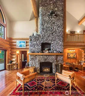 a living room with a fireplace a rug and a floor to ceiling window