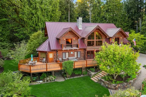 a front view of a house with a garden and trees