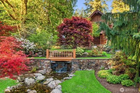 a view of a house with a small yard and a wooden deck