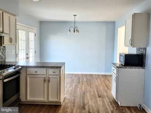 a kitchen with a sink a stove and cabinets