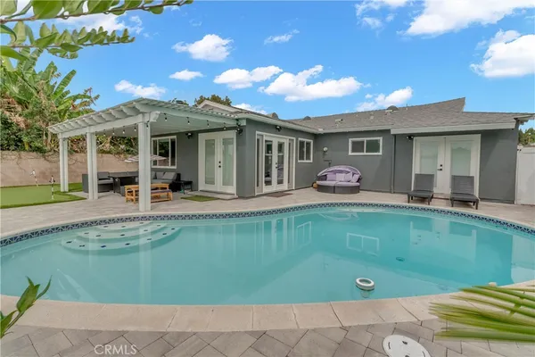 a front view of a house with swimming pool having outdoor seating