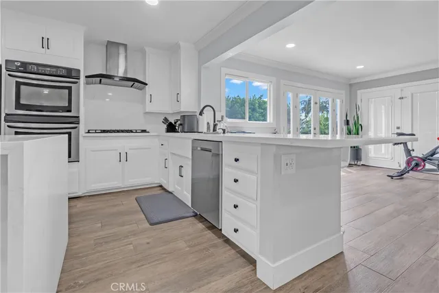 a kitchen with stainless steel appliances granite countertop a stove and white cabinets