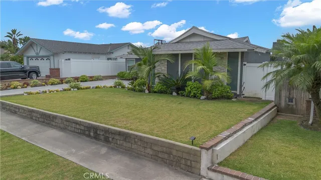 a view of a white house with a backyard and plants