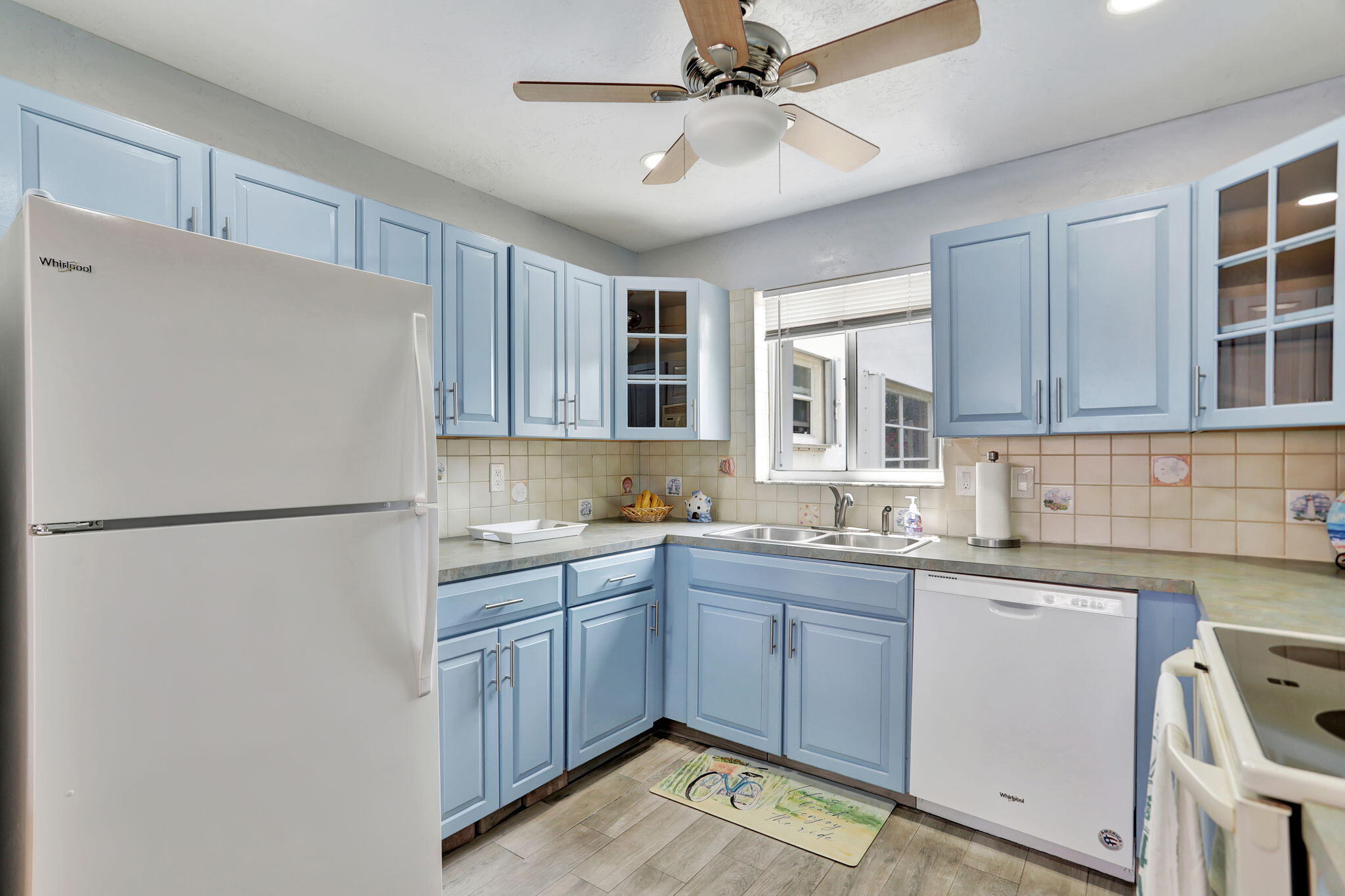 999 North Riverside Drive, Unit 3 Pompano Beach, FL 33062 - Photo 7 of 15 a white refrigerator freezer sitting inside of a kitchen with stainless steel appliances granite countertop cabinets and a refrigerator