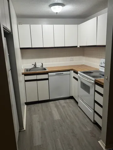 a kitchen with granite countertop cabinets stainless steel appliances and a sink