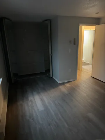 a view of a room with wooden floor and a window
