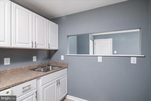 a kitchen with a sink cabinets and a window