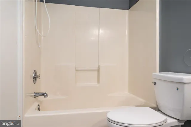 a white toilet sitting next to a bath tub