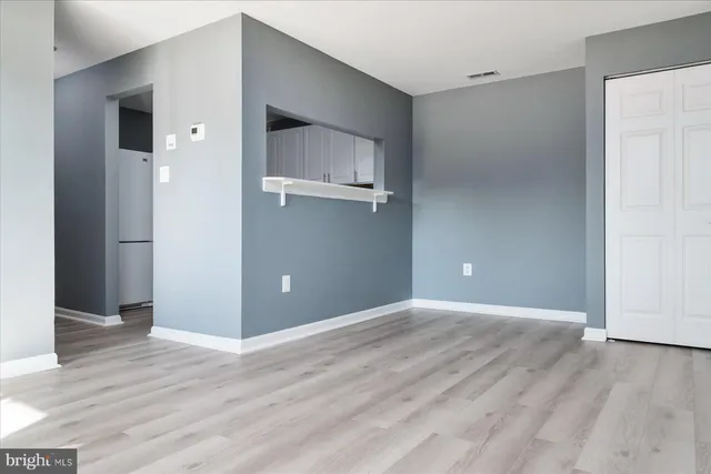 a view of an empty room with wooden floor