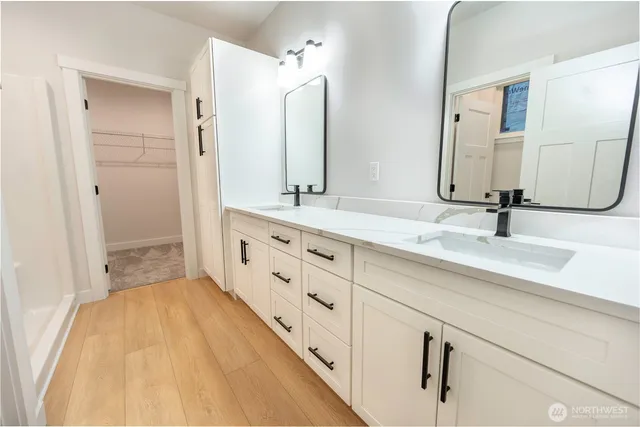 a spacious bathroom with a double vanity sink and mirror