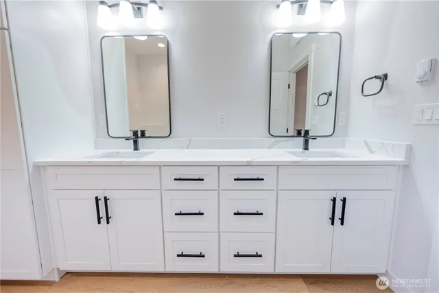 a bathroom with double vanity sinks and a mirror
